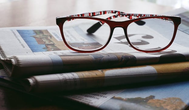 pair of reading glasses on a newspaper