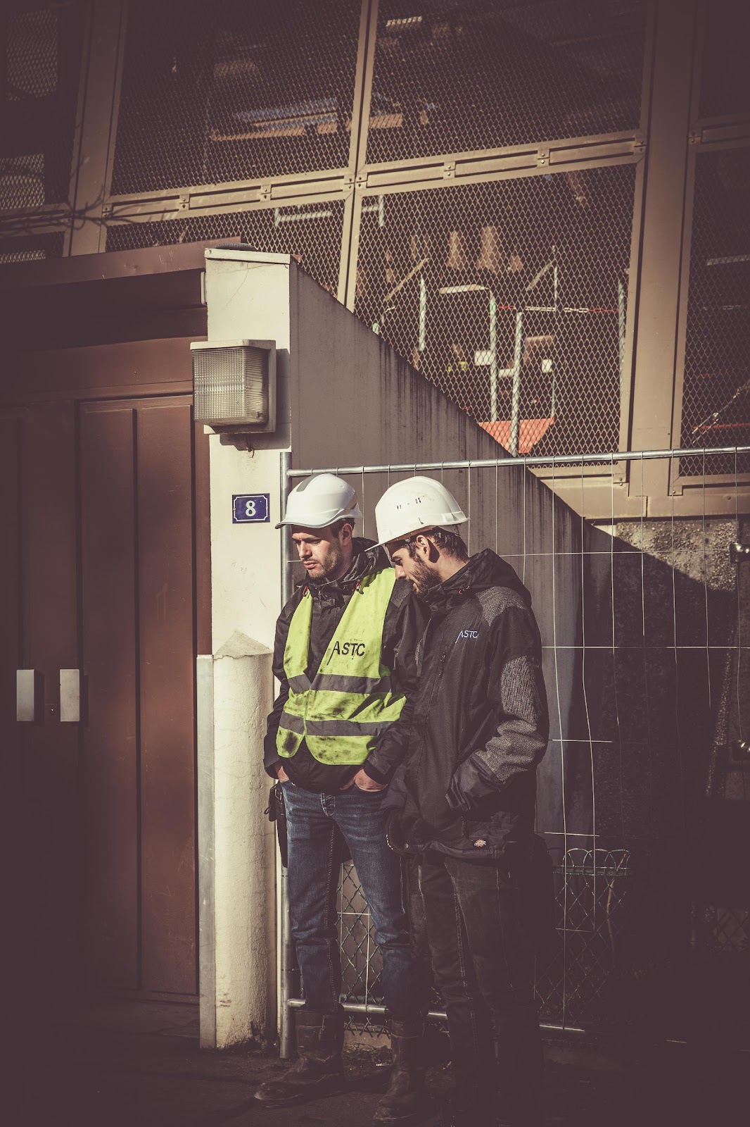 two men standing outside of a bulk material handling facility